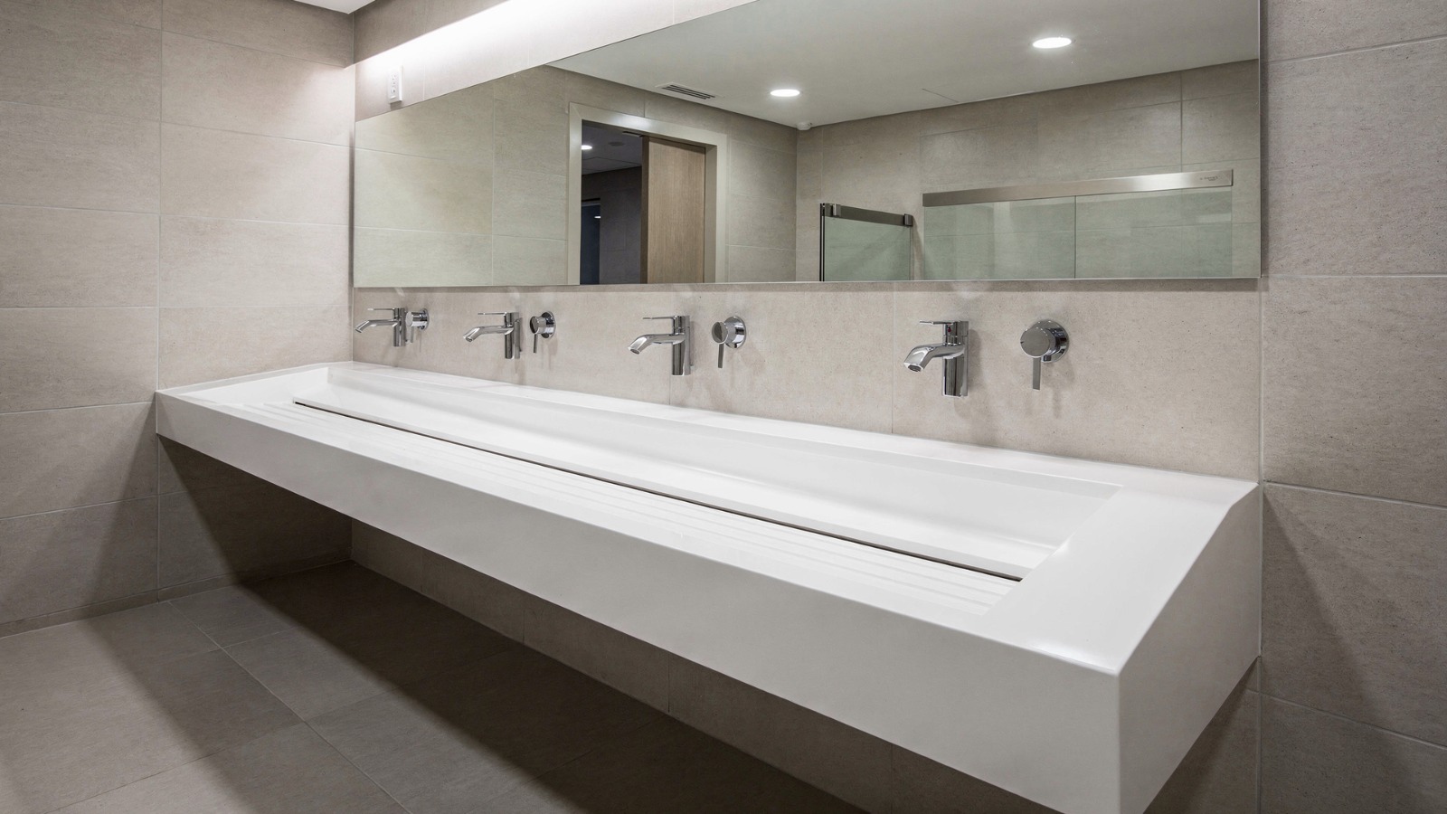 Encimera de Corian colectivo con lavabo en rampa para baños de centro comercial